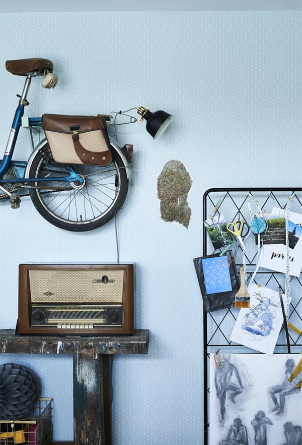 A vintage bike and trellis mounted on the wall.