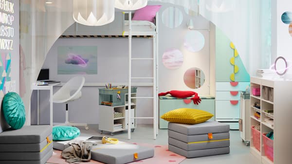 A VITVAL loft bed with desk top stands next to a SMÅSTAD storage combination with bench in a child’s room.