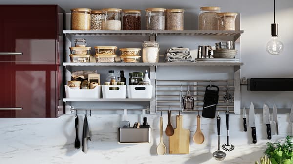 A wall-mounted KUNGSFORS kitchen storage series with glass jars with lids, white VARIERA storage boxes and hanging utensils.
