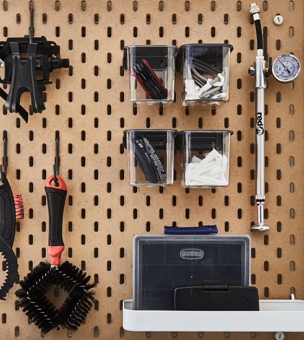 A wall panel holds tools for outdoor equipment.