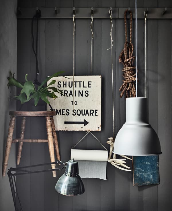 A wall rail with hooks and personal items like signs and plants hanging on display in a kitchen