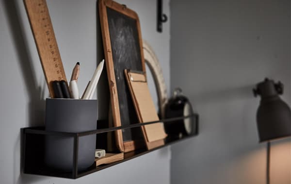 A wall shelf filled with study accessories in a gray room.