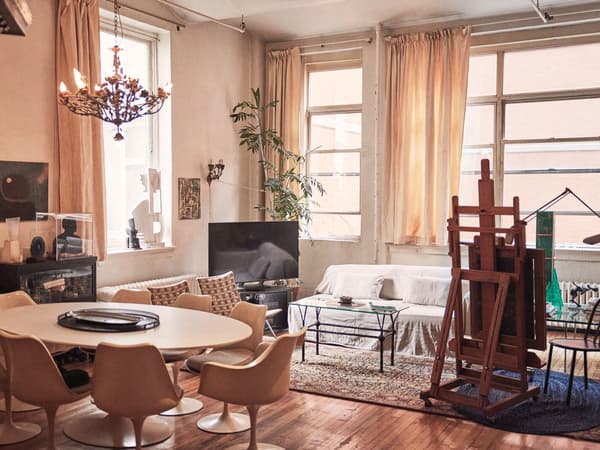 A warm-toned living room setting with large windows.