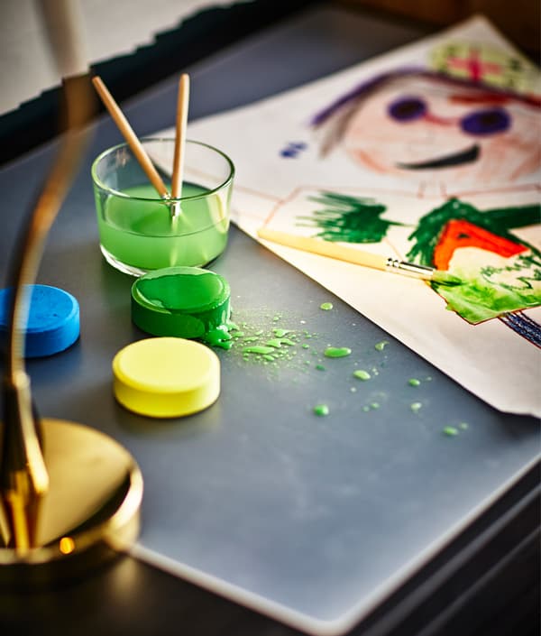 A water color painting is being created at the desk.