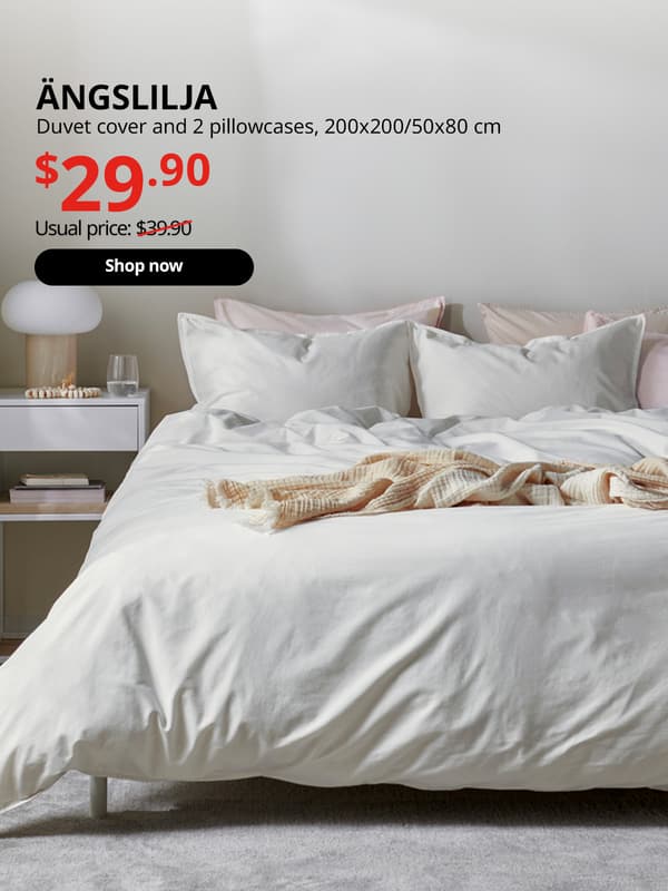 A white ÄNGSLILJA duvet cover and 2 pillowcases is used on this bedroom setting. Black text over image that reads "ÄNGSLILJA, Duvet cover and 2 pillowcases, 200x200/50x80 cm. Price at $29.90, Usual price $39.90"