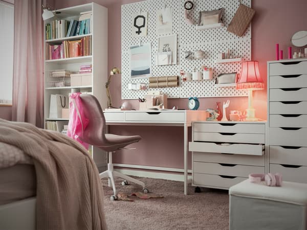 A white ALEX desk with drawer units from the same series, in a pink room with a pink office chair.