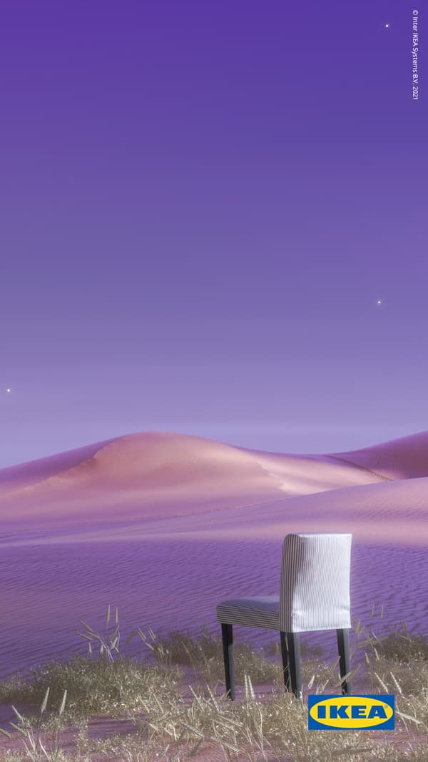 A white and blue-striped BERGMUND chair, with black legs, stands on sand in a violet-coloured desert landscape.