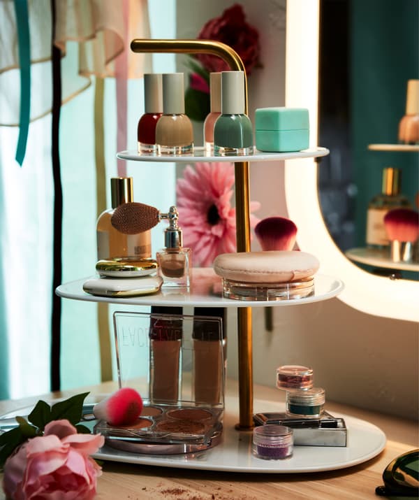 A white and brass FÖRÄDLA serving stand used for makeup instead of cookies.