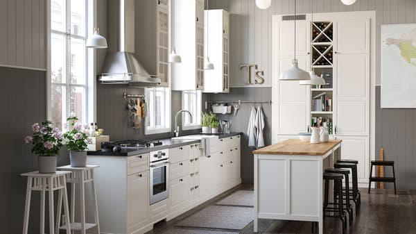 A white and grey rustic kitchen with a mix of closed and open white kitchen storage shelves and cabinets and an island.
