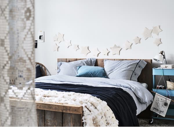 A white bedroom with blue striped bedding.