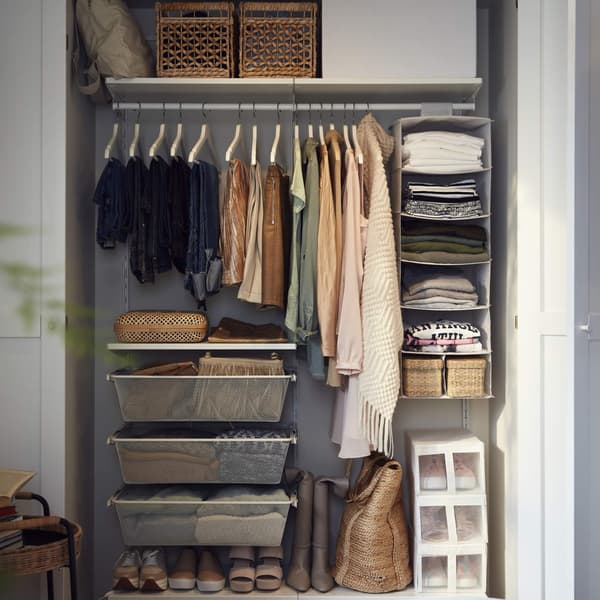 A white BOAXEL wardrobe combination with drawers and a rail holding clothes and a STUK hanging storage with 7 compartments.