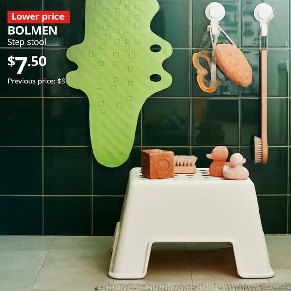 A white BOLMEN step stool is placed at the bathroom with Lower price tag. Price: $7.50. Previous price with red slash: $9.