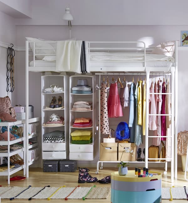 A white bunk bed with open storage below filled with organized clothing and accessories.