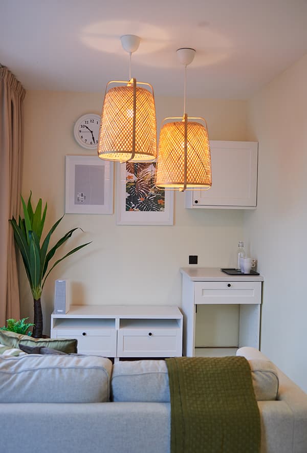 A white chest of drawer and desk beside each other.