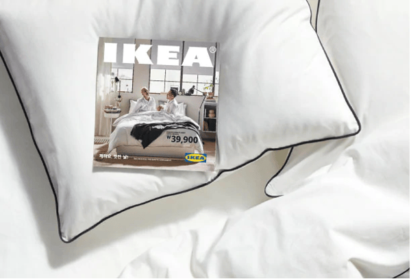 A white cushion with a ikea magazine