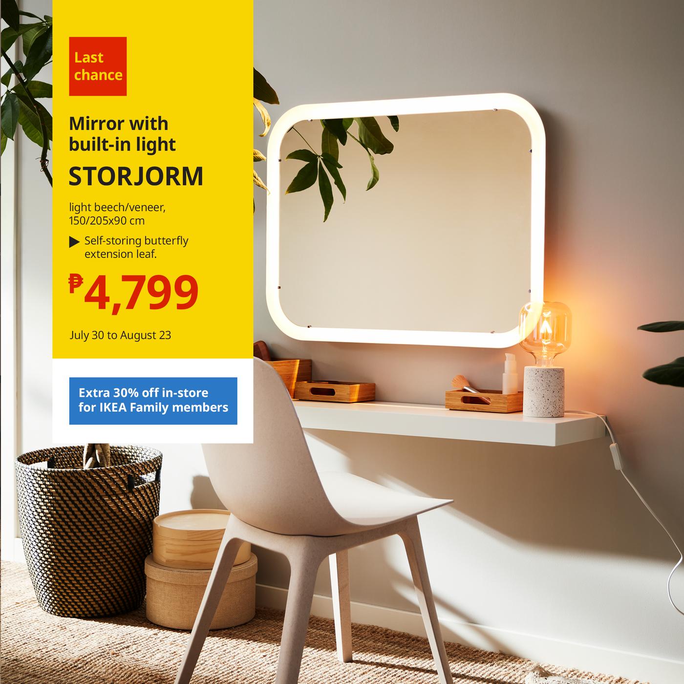 A white desk featuring a stylish lamp and a round mirror, creating a bright and inviting workspace.