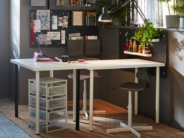 A white desk is in a cosy room with grey walls.