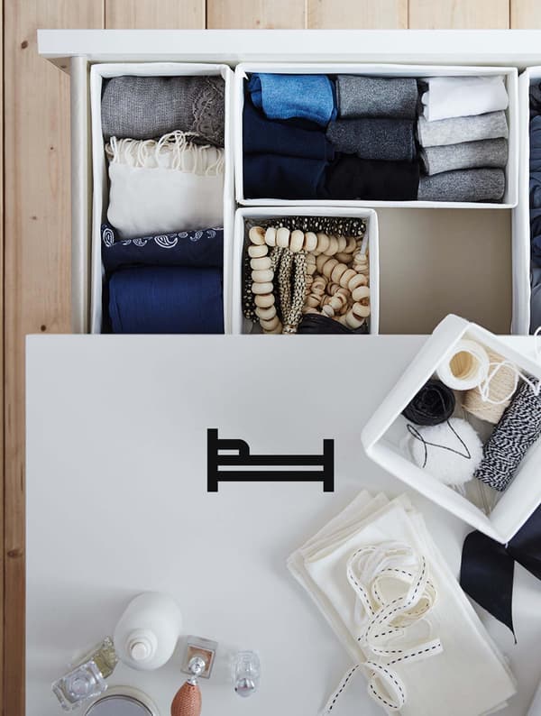 A white dresser with the drawer open shows organized clothing and a bed icon on the image.