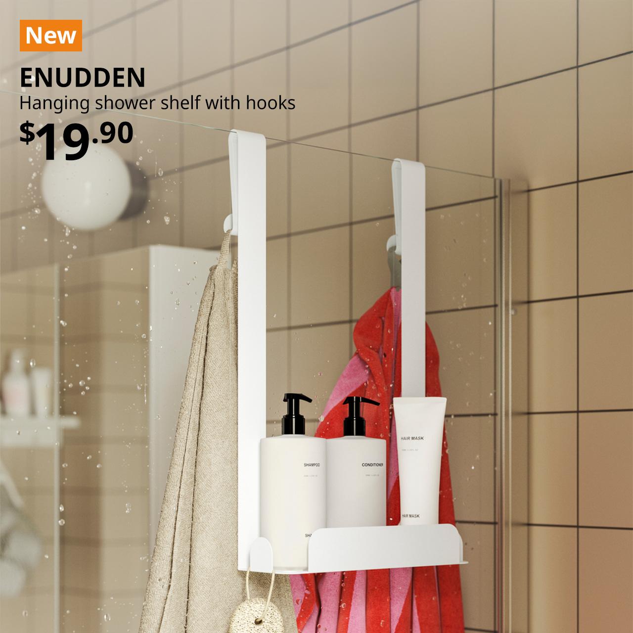 A white ENUDDEN hanging shower shelf with hooks is hung over the bathroom glass divider to hold the shampoo, shower gel and facial wash in a bathroom setting. An orange "NEW" label is displayed in the top left corner of the image, featuring white text that reads: "ENUDDEN, Hanging shower shelf with hooks, $19.90"
