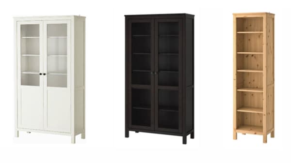A white glass door cabinet, a black brown glass door cabinet, and a wooden bookcase against a white background.