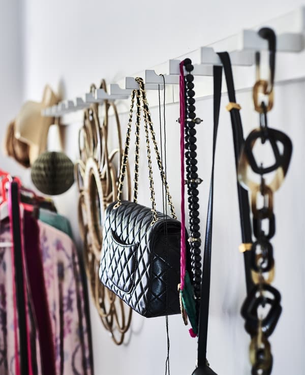 A white hook rack displaying bags and fashion items.