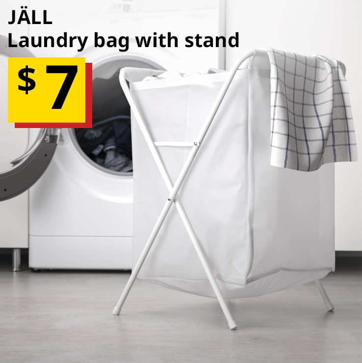 A white JÄLL laundry bag with stand is positioned in front of a white front load washing machine with a checkered cloth peeking over the top. Text on the top left of the image reads: JÄLL, laundry bag with stand. Price: $7. 