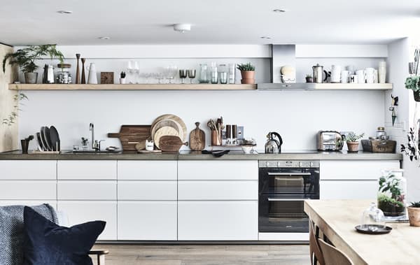 A white kitchen with concrete worktops and shelves.