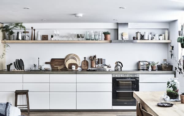 A white kitchen with concrete worktops and shelving.