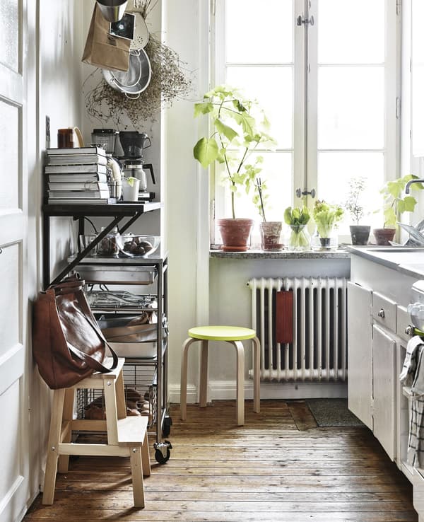 A white kitchen with open storage and a step stool.