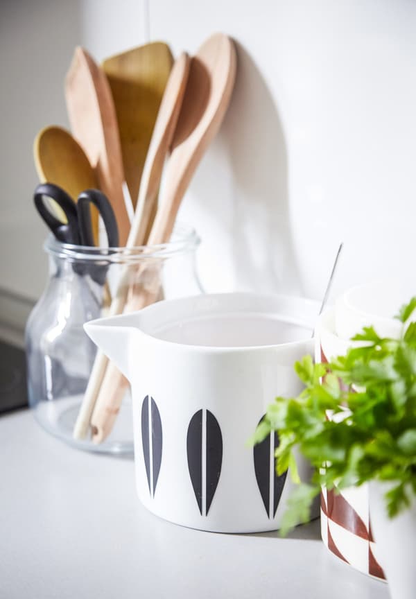 A white milk jug that’s been customised with black stickers.