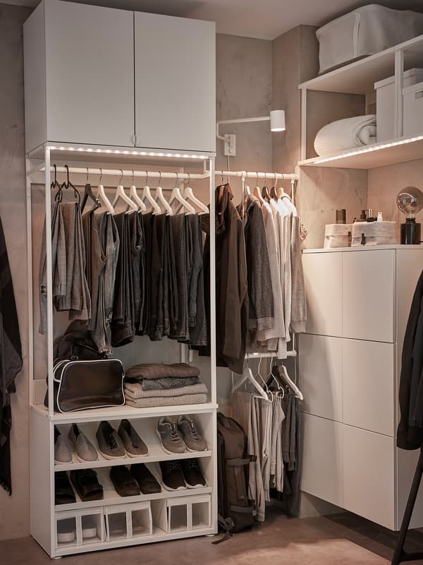 A white open wardrobe solution that includes clothes rails, shoe shelves, wall storage, lighting strips and boxes.