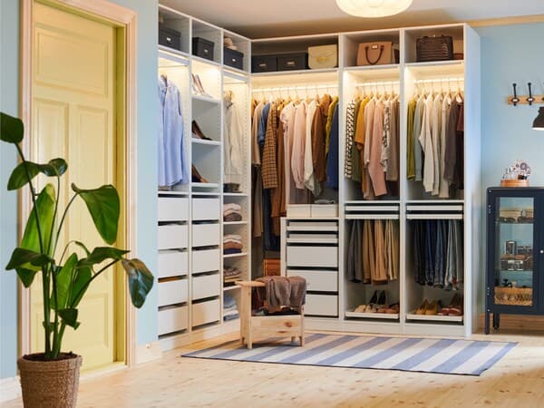 A white open wardrobe that goes around the corner.