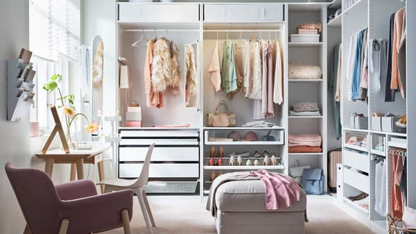 A white PAX wardrobe in a bedroom with shelves and drawers