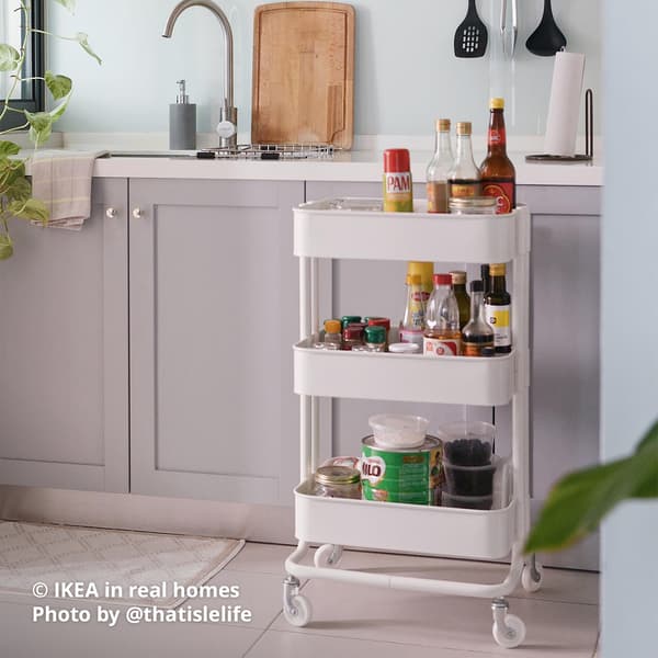 A white RÅSKOG trolley being utilised as a condiment and sauces trolley in a kitchen setting. IKEA in real homes Photo by @thatislelife