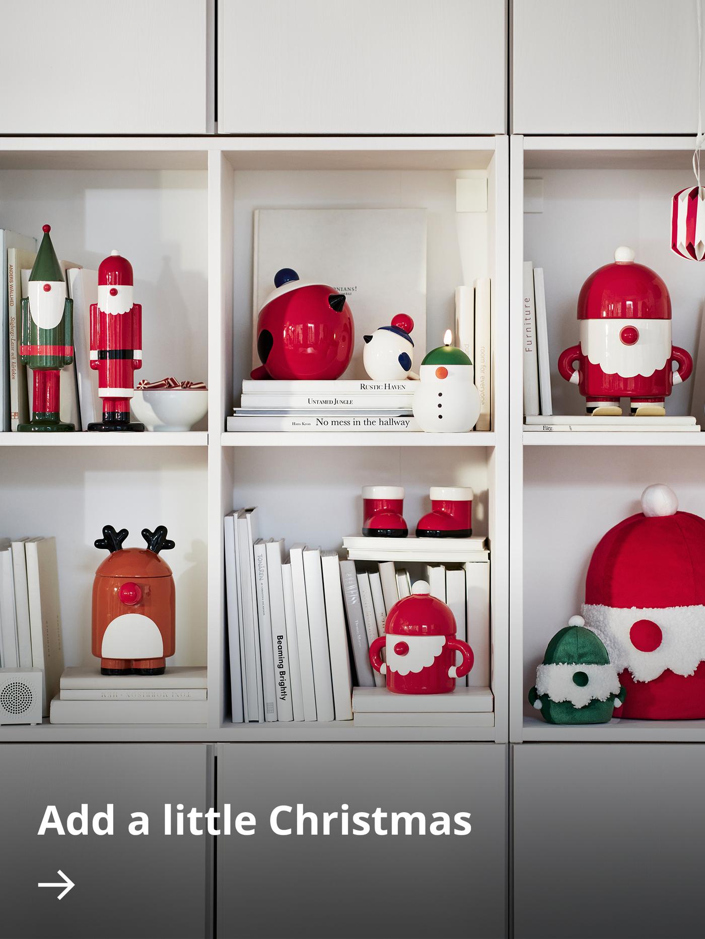 A white shelving unit filled with festive VINTERFINT ceramic collectables.