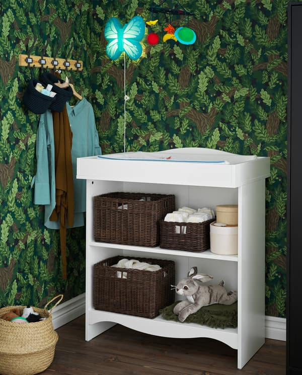 A white SMÅGÖRA changing table with two spacious shelves with towels, baskets and toys.