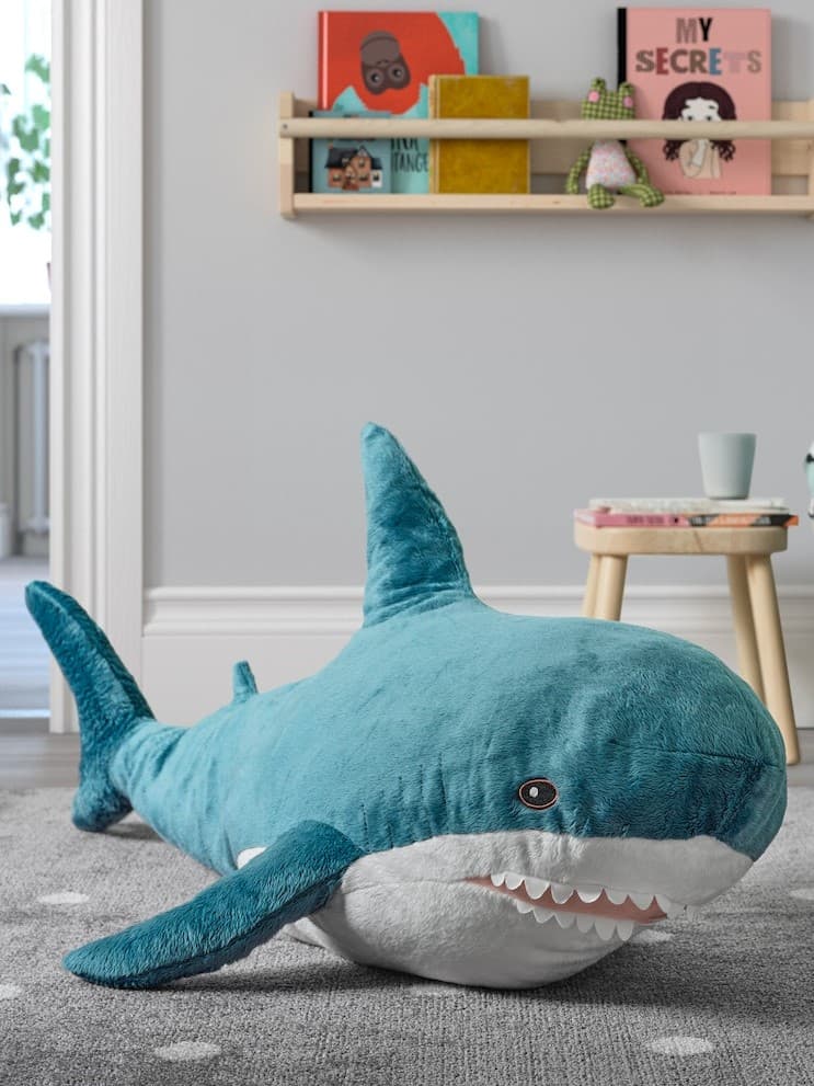A white SMÅGÖRA wardrobe stands in a kid’s room near a MINNEN extendable bed with BARNDRÖM bed linen.