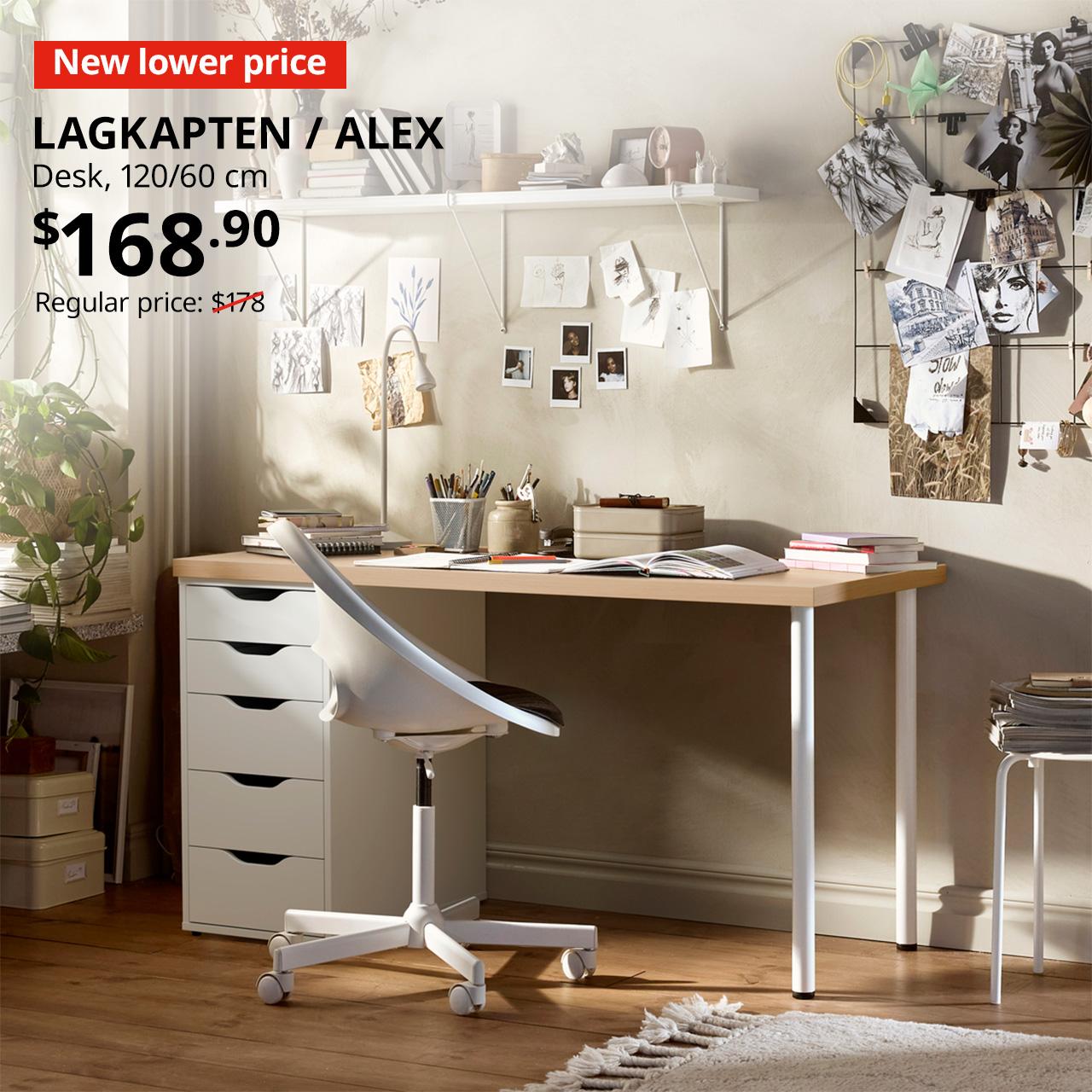 A white-stained oak-effect LAGKAPTEN tabletop with white ALEX drawer unit and a pair of white ADILS legs in a study room setting. On the top left corner, a red tag with white text that reads, "New lower price", followed by a black text overlay image that reads, "LAGKAPTEN / ALEX, Desk, 120x60 cm. $168.90. Regular price: $178"