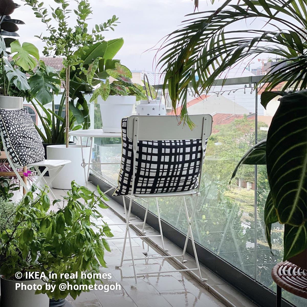 A white SUNDSÖ table and folding chairs being placed at the balcony that is nicely decorated with potted plants. Photo by instagrammer @houseeightthree for IKEA in real homes ©