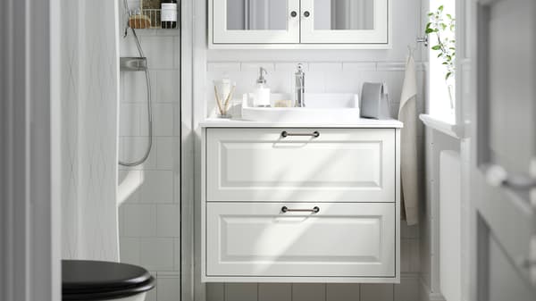 A white TÄNNFORSEN bathroom system with white marble effect RUTSJÖN wash-basin and tap.