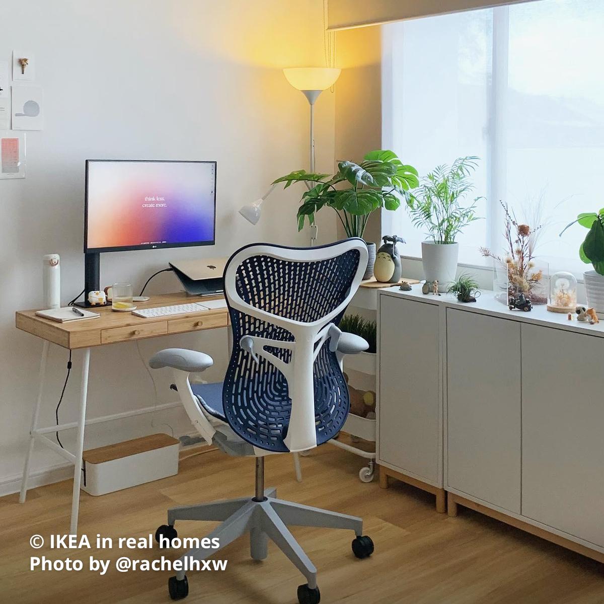 A white TÅGARP floor uplighter/reading lamp at the corner of the home office in-between a bamboo LILLÅSEN desk, a white RÅSKOG trolley and a white EKET cabinet combination with wood legs. Photo by instagrammer @rachelhxw from IKEA in real homes ©