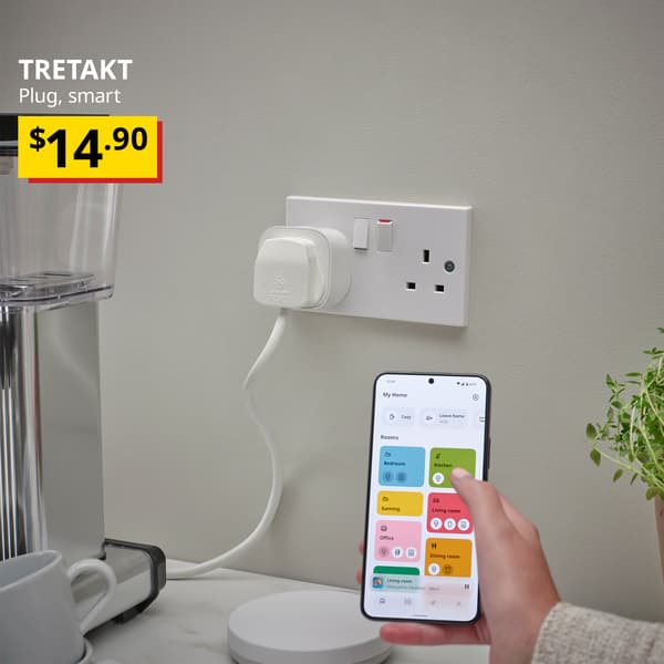 A white TRETAKT smart plug is being used for the blender in the kitchen with a mobile device showing the IKEA Smart Home device app. Text on the top left of the image reads: TRETAKT, plug, smart. Price: $14.90. 