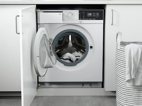 A white TVÄTTAD integrated washing machine in a white kitchen.