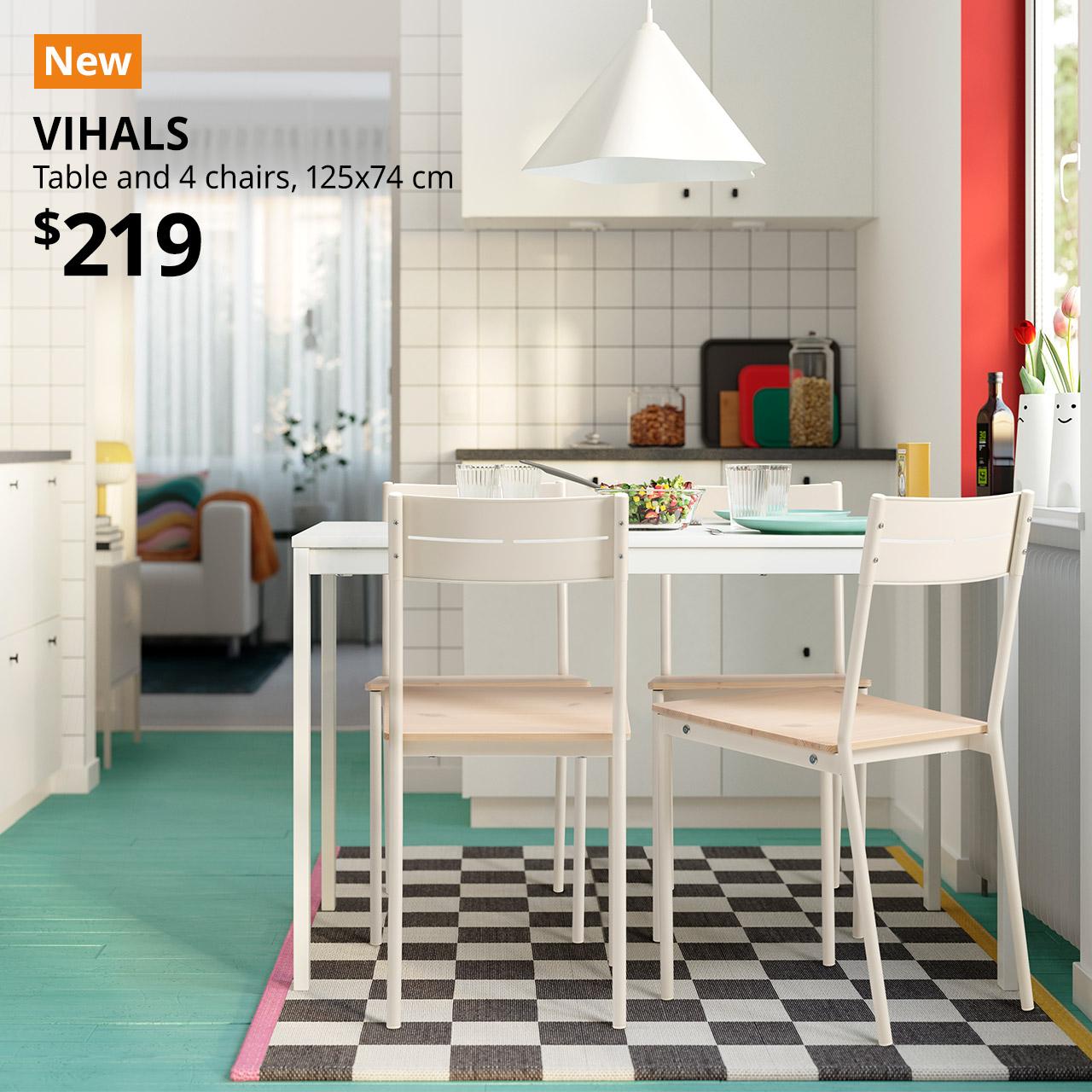 A white VIHALS table with 4 white/pine BUSLÄTT chair is placed in the dining area near the kitchen. A orange with white text that reads "New". Text on image reads "VIHALS, Table and 4 chairs, $219"