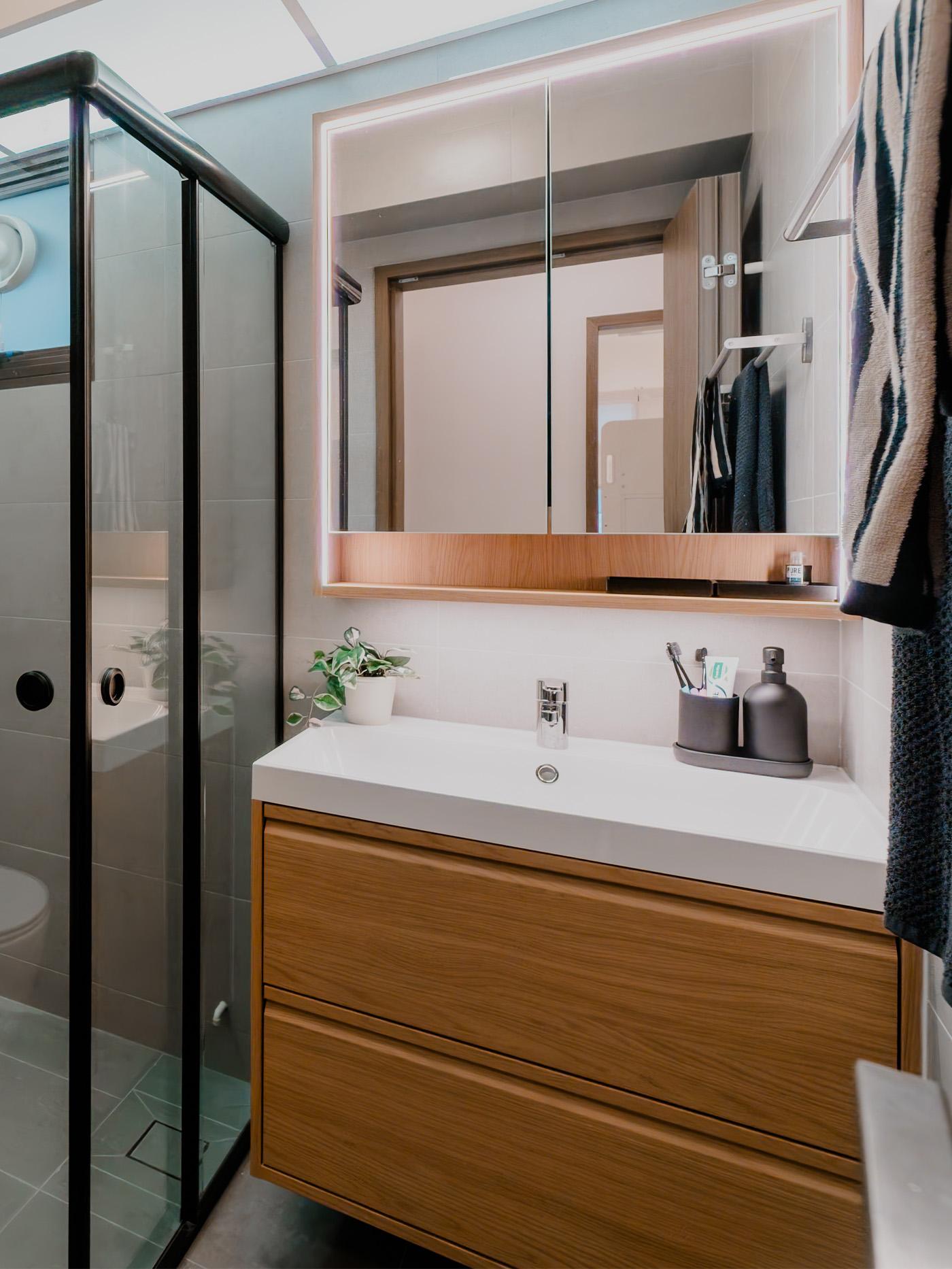 A wide shot of a bathroom from a traditional modern 4-room BTO flat in MacPherson, Singapore, designed by IKEA Home design service.
