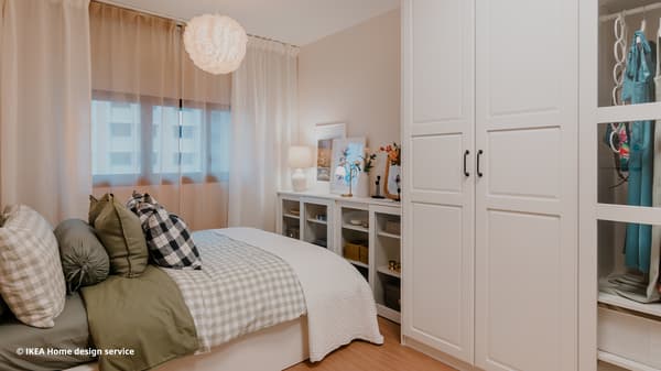 A wide shot of a master bedroom featuring a  a white MALM ottoman bed and a floor-to-ceiling PAX wardrobe from a traditional modern 4-room BTO flat in MacPherson, Singapore, designed by IKEA Home design service.