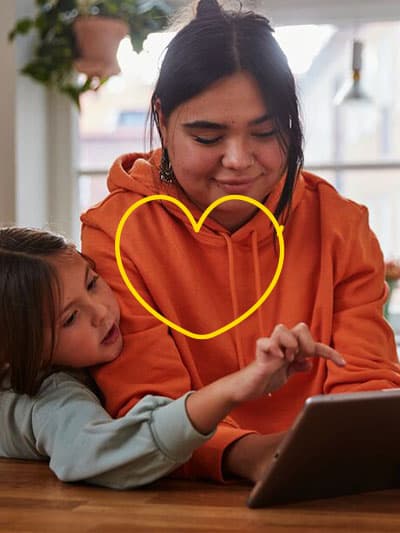 A woman and a child are looking at a tablet