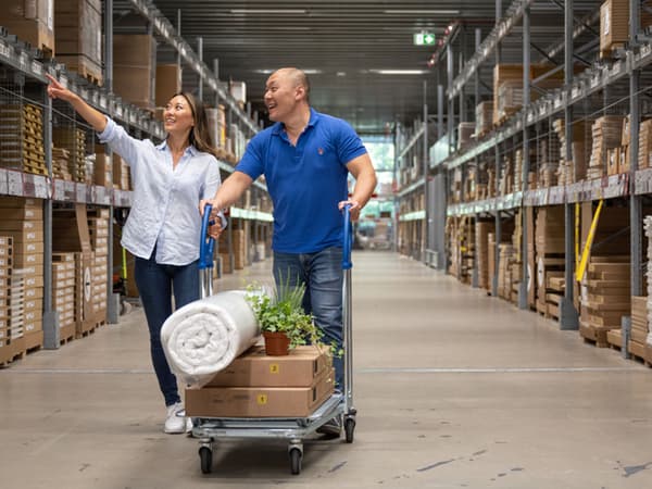 A woman and a man shopping at the IKEA self-serve area.