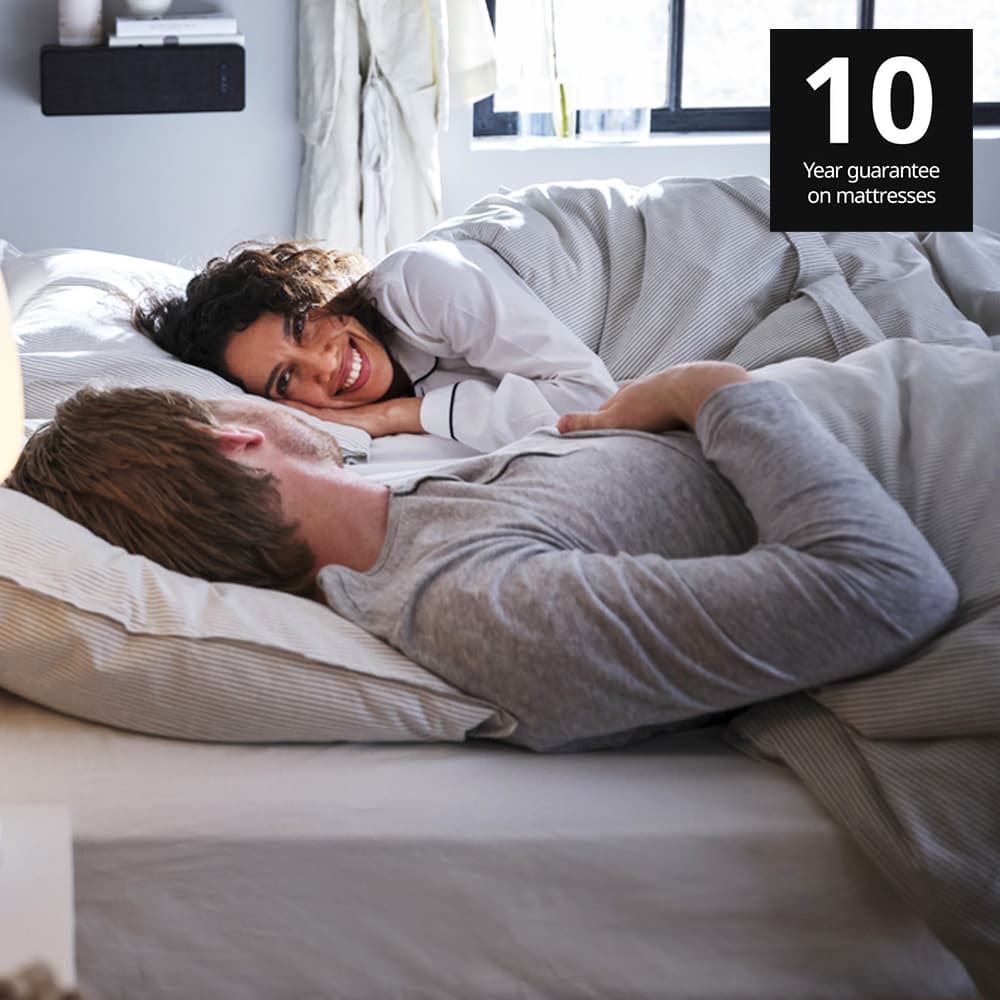 A woman and a man sleeping on a MAUSUND natural latex mattress. 10 year guarantee on IKEA mattresses.