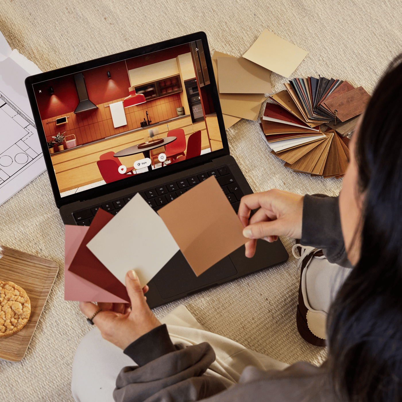 A woman comparing colour samples while planning on her laptop.